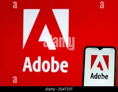 In dieser Abbildung ist ein Logo von Adobe, Inc. Zu sehen, das auf einem Smartphone angezeigt wird. Stockfoto