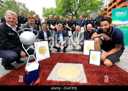 23. Juni 2021, Sachsen-Anhalt, Magdeburg: Bennett Wiegert (r), Trainer des Handball-Bundesligisten SC Magdeburg, und Lutz Trümper (m), Oberbürgermeister von Magdeburg, hocken vor der Granitbronze-Skulptur „Sports Walk of Fame“, die heute von den EHF-Europameisterschaftsgewinnerinnen des SC Magdeburg enthüllt wurde. Der SC Magdeburg hatte im Mai den Titel der EHF-Europaliga geholt. Die in den Bordstein eingebettete und dem „Walk of Fame“ in Hollywood nachempfundene Plakette soll diesen Erfolg und viele andere sportliche Spitzenleistungen der Handball-Bundesliga würdigen. Der „Sports Walk of Fame“, w Stockfoto