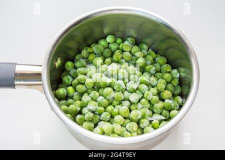 Gefrorene grüne Erbsen in einem Topf zum Kochen Stockfoto