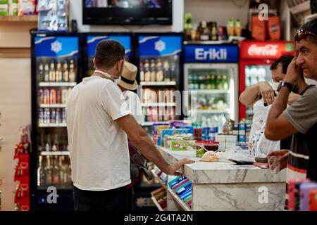 Kemer, Türkei - 25. Mai 2021: Türkischer Souvenirladen. Kunden an der Kasse zahlen für Einkäufe. Hochwertige Fotos Stockfoto