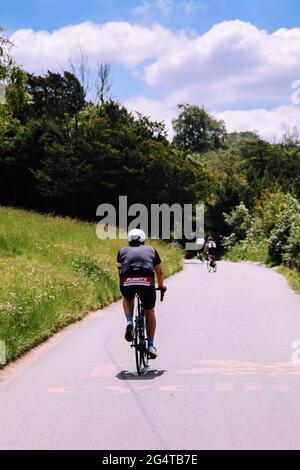 Radfahrer radeln auf einer Zickzack-Straße zurück zur Kamera bis zum National Trust Box Hill, Surrey Hills, England, Großbritannien, tagsüber Sommer 2021 Stockfoto