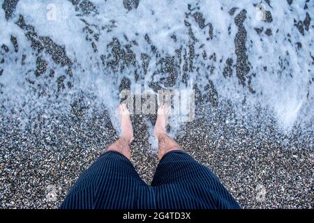 Erwachsener Mann, der sich am Strand abkühlt Stockfoto