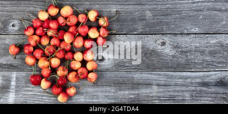 Frische Bio-rohe rainier-Kirschen in einem Haufen auf alten Holzplanken Stockfoto