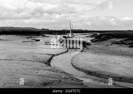 Einer der Bäche, die bei Ebbe bei Brancaster Staith gesehen wurden, in Monochrone gesehen. Stockfoto