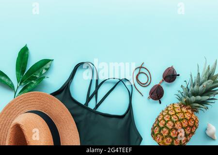 Damen Sommerkleidung, Accessoires und Ananas auf blauem Hintergrund. Beauty, Mode, Sommerurlaubskonzept. Draufsicht, flach liegend, Kopierbereich. Stockfoto