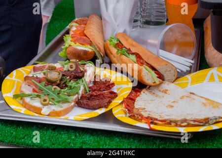 Sandwich mit Rucola, Schinken, Käse, Jalapeno, getrockneten Tomaten, Salami - Nahaufnahme Stockfoto