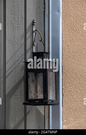 Helsinki / Finnland - 22. JUNI 2021: Eine alte Metalllaterne, die an einer weißen Holzwand hängt. Stockfoto