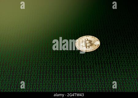 Isolierte Goldkryptowährung auf einem dunklen abstrakten Hintergrund, auf dem sich ein Mosaik aus grüner Null und einer Zahl mit einer rauen Textur befindet. Es gibt eine l Stockfoto