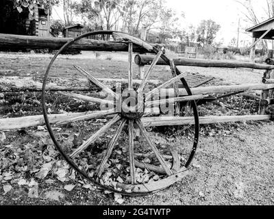 Ein altes, gebrochenes Wagenrad in Schwarz und Weiß, in der späten Nachmittagssonne in Escalante, Utah, USA Stockfoto