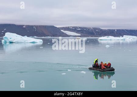 Zodiac-Boot mit Öko-Touristen besuchen Monacobreen, Gletscher in Haakon VII Land, das in Liefdefjorden, Spitzbergen / Svalbard, Norwegen, entlarvt Stockfoto