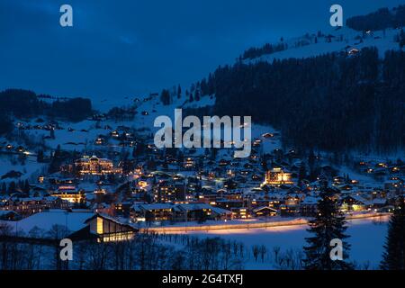 Nächtliche Winterlandschaft Blick auf die schneebedeckte Stadt Engelberg im Kanton Obwalden, Zentralschweiz, beleuchtet von Straßenlaternen und Häusern Stockfoto