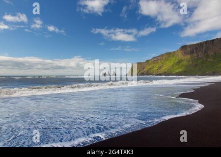 Schwarzer Sandstrand und Reynisdrangar, Basaltmeerhaufen in der Nähe des Dorfes Vík í Mýrdal im Sommer, Südisland Stockfoto