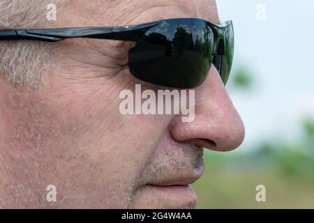 Nahaufnahme des Gesichts eines Mannes in dunkler Sonnenbrille. Stock-Fotografie Stockfoto