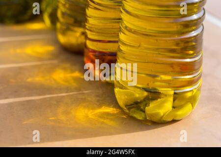 Handgefertigte Serie von köstlichen goldenen Olivenölen mit Knoblauch-Chili und mediterranen Kräutern Stockfoto