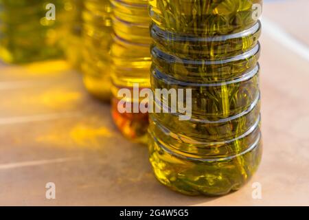 Nahaufnahme von kaltgepressten Olivenölvarianten mit Rosmarin und aromatischen mediterranen Kräutern Stockfoto