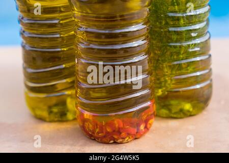 Traditionelle kaltgepresste aromatische Olivenöle mit würzigem Chili und Kräutern Stockfoto