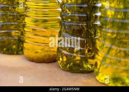 Nahaufnahme von aromatischen goldenen Olivenölen in verschiedenen Geschmacksrichtungen mit mediterranen Kräutern und Knoblauch Stockfoto
