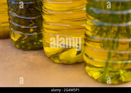 Nahaufnahme von kaltgepressten goldenen Olivenölen in verschiedenen aromatischen Geschmacksrichtungen mit mediterranen Kräutern und Knoblauch Stockfoto