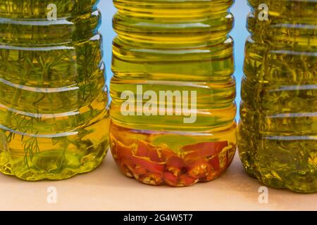 Auswahl an aromatischen Olivenölen, angereichert mit würzigem Chili und mediterranen Kräutern Stockfoto