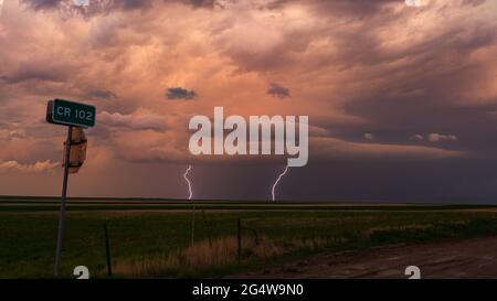 Mehrere Blitzschläge schlagen in der Ferne unter einem dunklen und bedrohlichen Himmel ab, während ein Gewitter durch den Osten Colorados zieht Stockfoto