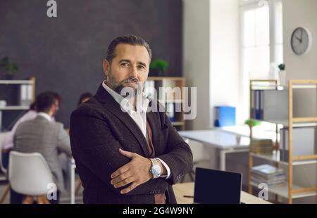 Stolzer und erfolgreicher seriöser, reifer kaukasischer Teamleiter im Büro Stockfoto