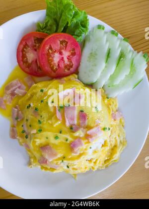 Jasminreis mit Schinken-Omelette, serviert mit den Tomaten- und Gurkenschiebern auf der sauberen weißen Platte im lokalen Restaurant, oberhalb mit dem CO Stockfoto