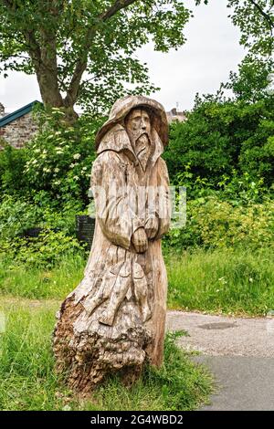 Kettensägen-Schnitzwerk des Fischers (gegenüber seiner Frau stehend) von Tim Burgess auf dem Kirchhof der Heiligen Dreifaltigkeit, Morecambe, Lancashire Stockfoto