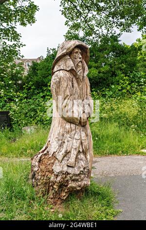 Kettensägen-Schnitzwerk des Fischers (gegenüber seiner Frau stehend) von Tim Burgess auf dem Kirchhof der Heiligen Dreifaltigkeit, Morecambe, Lancashire Stockfoto