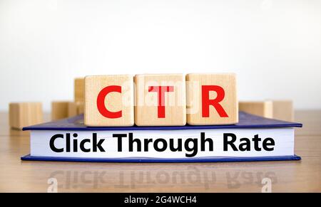 CTR durch das Tarif-Symbol klicken. Holzwürfel auf dem Buch mit den Worten „CTR click through Rate“. Weißer Hintergrund. Business- und CTR-Klickraten-Konzept Stockfoto