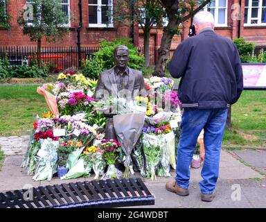 Blumen umgeben die Alan Turing Statue und das Denkmal, Sackville Gardens, Manchester, England, Großbritannien, Vereinigtes Königreich, am 23. Juni 2021, dem Jahrestag von Turing's Geburtstag. Alan Mathison Turing OBE war ein englischer Mathematiker, Informatiker, Logiker und Kryptanalyst. Im 2. Weltkrieg leitete er ein Team, das dafür verantwortlich war, deutsche Cipher der Enigma-Maschine zu brechen. Turing hatte damals Einfluss auf die Entwicklung der Informatik an der University of Manchester. Stockfoto