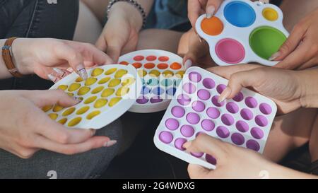 Mädchen spielen mit einfachen Grübchen entspannende Spielzeug und Pop it. Stockfoto