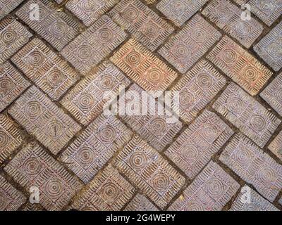Ausgefallene Ziegelsteinpflaster mit geschnitzten dekorativen konzentrischen Kreisen und Linien in Fischgrätmuster entlang eines Gehwegs in Columbus, Ohio. Stockfoto