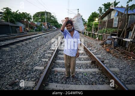 Kalkutta, Indien. Juni 2021. Biswanath Haldar, 50 Jahre alt, ist ein Eisenbahnhändler und läuft auf der Eisenbahnstrecke, da die lokalen Zugverbindungen aufgrund der staatlichen Sperrbeschränkungen nicht wieder aufgenommen wurden. Kredit: SOPA Images Limited/Alamy Live Nachrichten Stockfoto