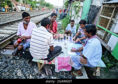Kalkutta, Indien. Juni 2021. Die Menschen, die an den Bahngleisen Karten spielen, als Nahverkehrszüge, haben aufgrund staatlicher Sperrbeschränkungen noch nicht begonnen. (Foto von Dipayan Bose/SOPA Images/Sipa USA) Quelle: SIPA USA/Alamy Live News Stockfoto
