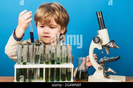 Junge Wissenschaftler im Labor. Nettes Kind macht Wissenschaft Experiment. Kleines Kind mit Reagenzgläsern und Mikroskop. Bildung. Stockfoto