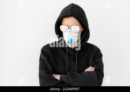 Frau in schwarzer Jacke mit Brille und Gesichtsmaske Stockfoto