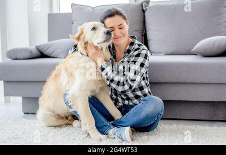 Schöne Frau kuscheln schönen Hund in hellen Raum Stockfoto