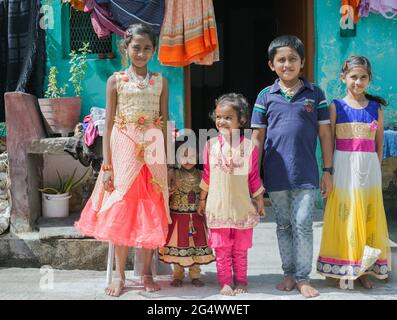 Familienfoto von elegant gekleideten kleinen indischen Kindern in ihren Partykittel, die für die Kamera posieren, Mysore, Karnataka, Indien Stockfoto