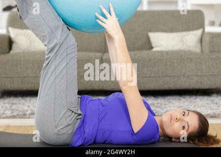Eine Schwangerin macht mit einem Fitball Entspannungsübungen Stockfoto