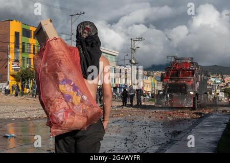 Bogota, Kolumbien. Juni 2021. Ein Demonstranten trägt Debree in einem Lappen, als Zusammenstöße zwischen Demonstranten und kolumbianischer Bereitschaftspolizei regierungsfeindliche Proteste in Bogota, Kolumbien, gegen die Regierung von Präsident Ivan Duque, Ungleichheiten und Autoritätsmissbrauch durch die Polizei ausbrechen. Kredit: Long Visual Press/Alamy Live Nachrichten Stockfoto