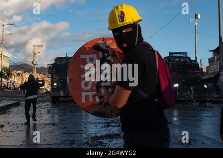 Bogota, Kolumbien. Juni 2021. Ein Demonstrator hält ein Straßenschild als Schild, als Zusammenstöße zwischen Demonstranten und kolumbianischer Bereitschaftspolizei in Bogota Kolumbien zu regierungsfeindlichen Protesten gegen die Regierung von Präsident Ivan Duque, Ungleichheiten und Autoritätsmissbrauch durch die Polizei führen. Kredit: Long Visual Press/Alamy Live Nachrichten Stockfoto