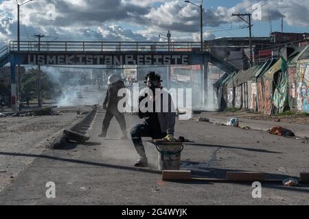 Bogota, Kolumbien. Juni 2021. Ein Demonstrator benutzt eine Gasmaske mitten in einer Tränengaswolke, als Zusammenstöße zwischen Demonstratros und der kolumbianischen Bereitschaftspolizei regierungsfeindliche Proteste in Bogota, Kolumbien, gegen die Regierung von Präsident Ivan Duque, Ungleichheiten und Autoritätsmissbrauch durch die Polizei ausbrechen. Kredit: Long Visual Press/Alamy Live Nachrichten Stockfoto