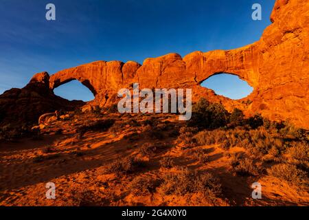 Felsformation des Nord- und Südfensters bei Sonnenaufgang im Arches National Park, Utah Stockfoto