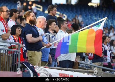 Foxborough Massachusetts, USA. Juni 2021. Ein Fan winkt während der Nationalhymne beim MLS-Spiel zwischen den New Yorker Red Bulls und der New England Revolution im Gillette Stadium in Foxborough, Massachusetts, eine stolze Flagge. New England besiegt New York 3-2. Eric Canha/CSM/Alamy Live News Stockfoto