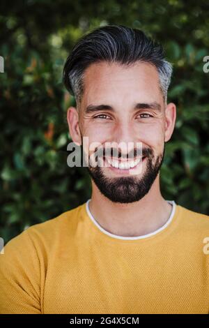 Bärtiger Mann mit mittlerem Erwachsenen, der im Park lächelt Stockfoto