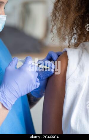 Krankenschwester, die im Krankenhaus einen COVID-19-Impfstoff in den Arm des Patienten injiziert hat Stockfoto