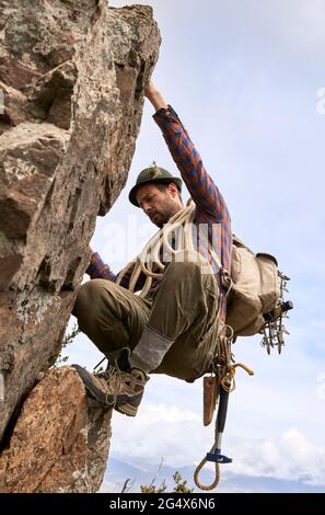 Mittelalter Bergsteiger mit Rucksack und Kletterfelsen Stockfoto