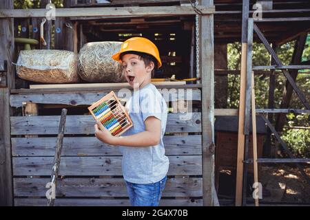 Netter Junge, der Abakus im Hinterhof hält Stockfoto