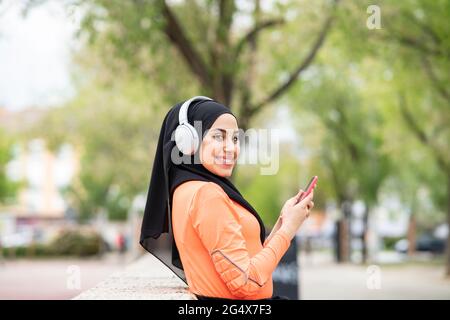 Junge Frau mit Kopfhörern und Smartphone Stockfoto