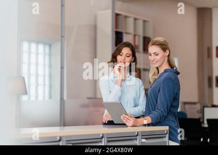 Weibliche Kollegen diskutieren über digitale Tablets im Büro Stockfoto